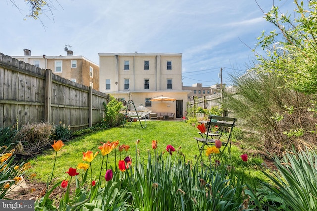 back of property featuring a yard and fence