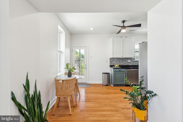 interior space featuring a ceiling fan, baseboards, recessed lighting, light wood-type flooring, and visible vents