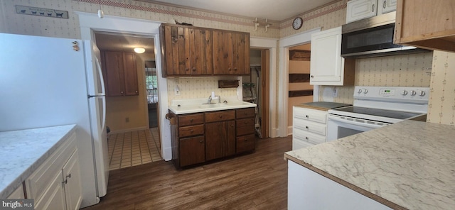 209 N Pine St, Seaford, DE 19973 - kitchen with white appliances, wallpapered walls, dark wood-style flooring, decorative backsplash, and light countertops