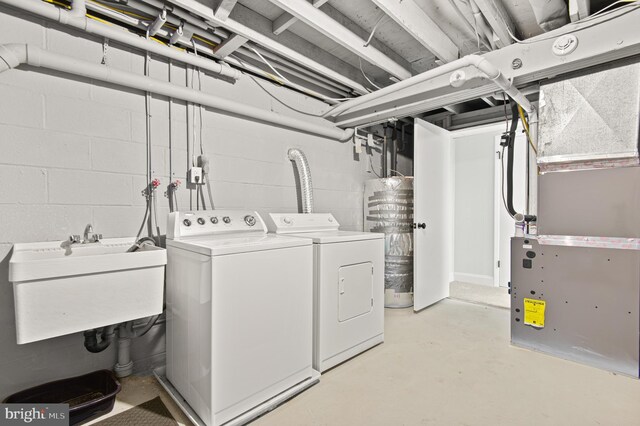 laundry room featuring a sink, concrete block wall, washer and dryer, and laundry area