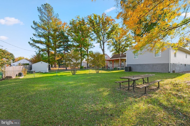 view of yard featuring central AC unit and fence