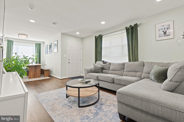living room with recessed lighting, dark wood-type flooring, and baseboards