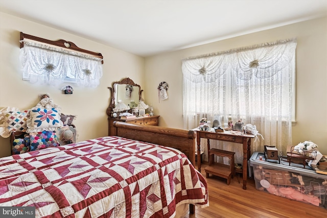 bedroom featuring wood finished floors and multiple windows