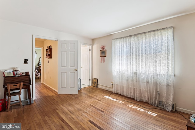 interior space featuring wood-type flooring and baseboards
