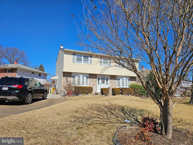 multi unit property featuring a chimney and a front yard