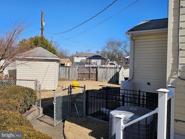 view of yard with a gate, fence private yard, and central air condition unit