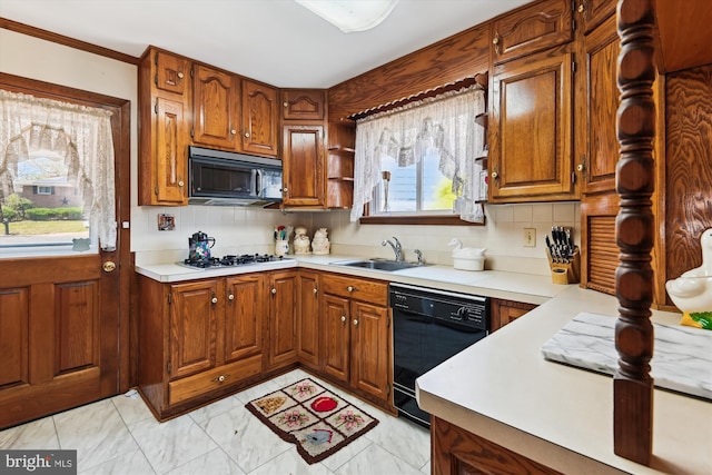 kitchen with light countertops, brown cabinets, a sink, and black appliances