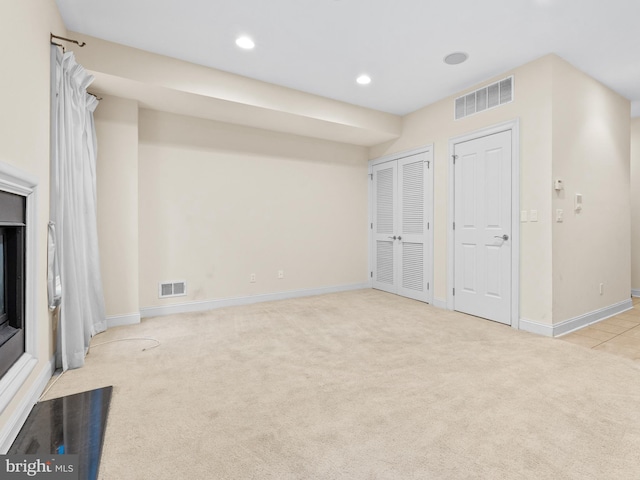 unfurnished living room featuring recessed lighting, baseboards, visible vents, and light colored carpet