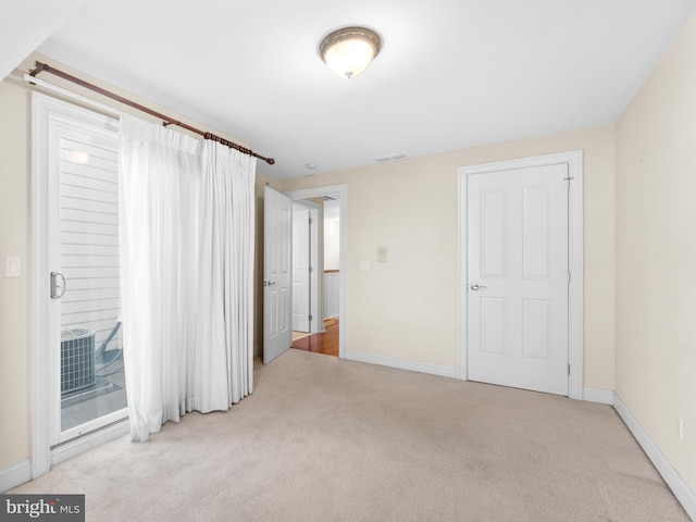 unfurnished bedroom featuring baseboards, access to outside, visible vents, and carpet