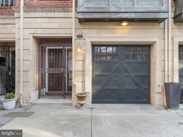 view of exterior entry with a garage and concrete driveway