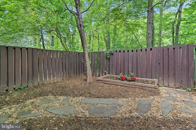 view of yard featuring a fenced backyard and a vegetable garden