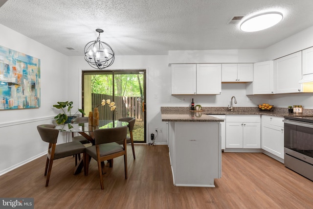 kitchen featuring electric range, baseboards, an inviting chandelier, and wood finished floors