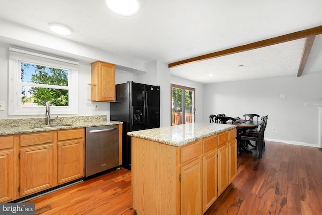 kitchen with wood finished floors, light stone countertops, a center island, a sink, and dishwasher