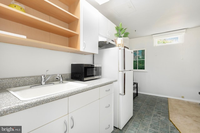 kitchen featuring freestanding refrigerator, white cabinetry, open shelves, and a sink