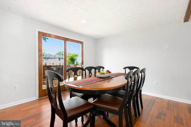 dining area featuring baseboards, recessed lighting, and wood finished floors