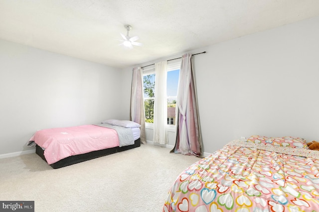 bedroom with a ceiling fan, baseboards, and carpet