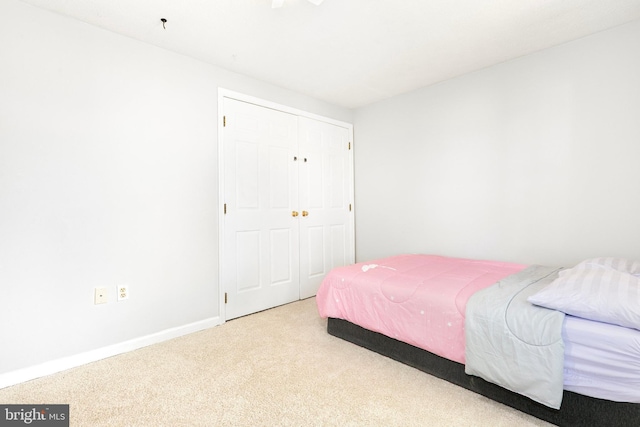 carpeted bedroom with baseboards and a closet