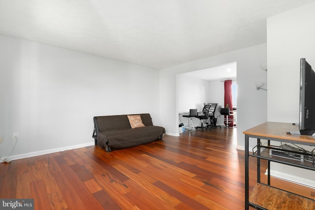 sitting room with baseboards and wood finished floors