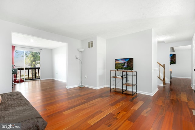 living area featuring visible vents, baseboards, and wood finished floors