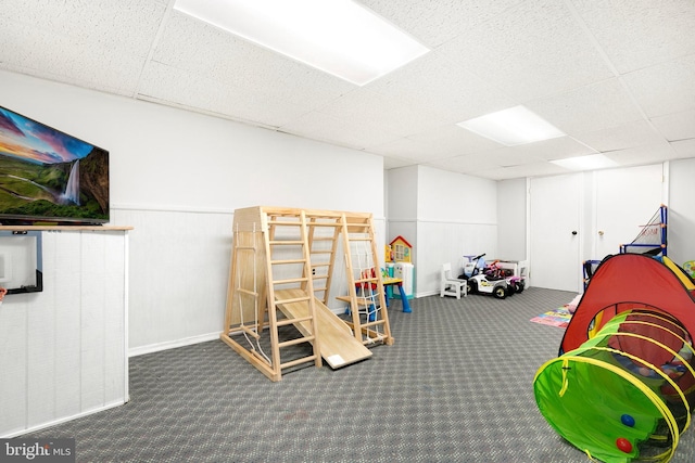 game room featuring a paneled ceiling and carpet