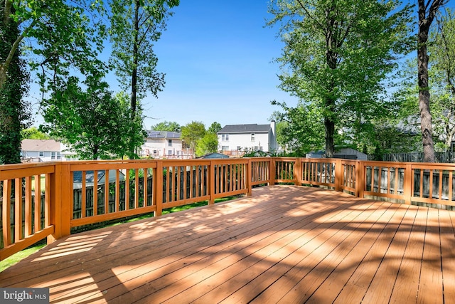 wooden deck featuring a residential view and a fenced backyard