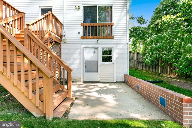 rear view of property with fence, a patio, stairs, and brick siding