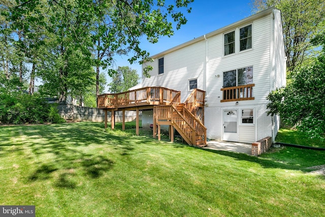 rear view of property with fence, a deck, stairway, a lawn, and a patio