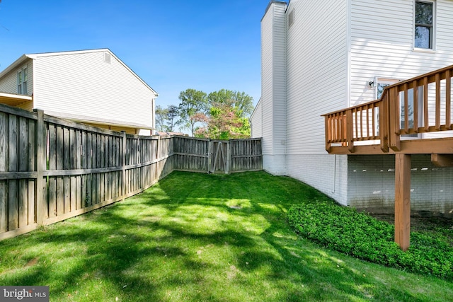 view of yard with a fenced backyard and a wooden deck