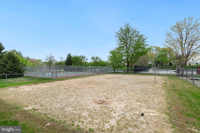 view of community featuring fence and a tennis court