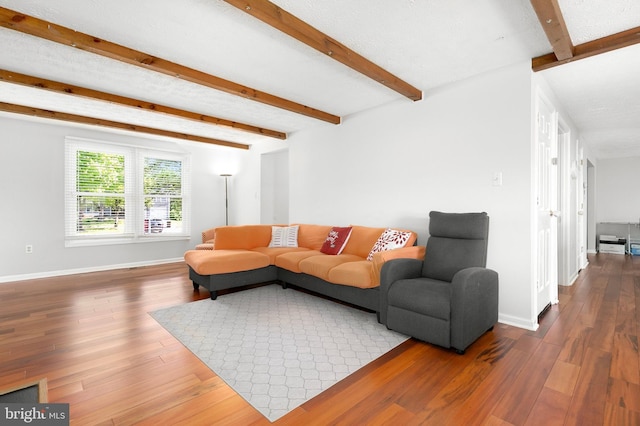 living room featuring baseboards, beamed ceiling, and wood finished floors