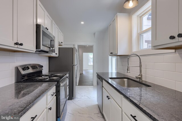311 E Frederick St, Lancaster, PA 17602 - kitchen with appliances with stainless steel finishes, backsplash, light marble finish floors, dark stone countertops, and white cabinets