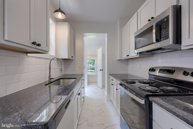 311 E Frederick St, Lancaster, PA 17602 - kitchen featuring appliances with stainless steel finishes, light marble finish flooring, dark stone countertops, tasteful backsplash, and hanging light fixtures
