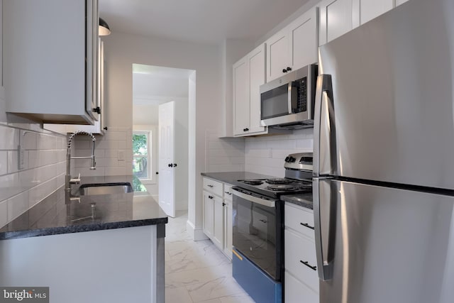 311 E Frederick St, Lancaster, PA 17602 - kitchen with appliances with stainless steel finishes, light marble finish floors, white cabinetry, backsplash, and dark stone counters