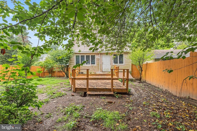 rear view of property with a fenced backyard and a deck
