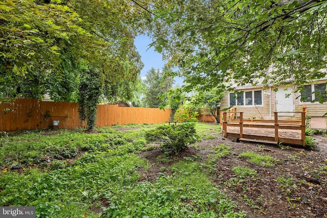 fenced backyard featuring a deck