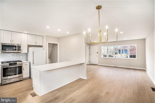 3839 Chalfont Dr, Philadelphia, PA 19154 - kitchen with visible vents, light wood-style floors, a chandelier, light countertops, and appliances with stainless steel finishes