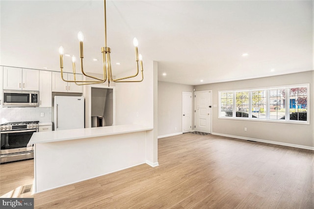 3839 Chalfont Dr, Philadelphia, PA 19154 - kitchen featuring white cabinets, light countertops, light wood-style floors, decorative backsplash, and appliances with stainless steel finishes
