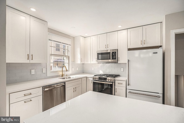 3839 Chalfont Dr, Philadelphia, PA 19154 - kitchen featuring a sink, decorative backsplash, stainless steel appliances, light countertops, and white cabinetry