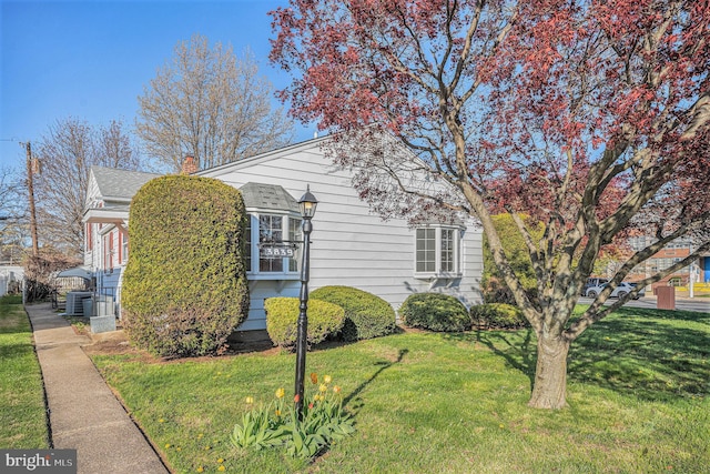 3839 Chalfont Dr, Philadelphia, PA 19154 - view of property exterior featuring a lawn, a chimney, roof with shingles, and central AC unit