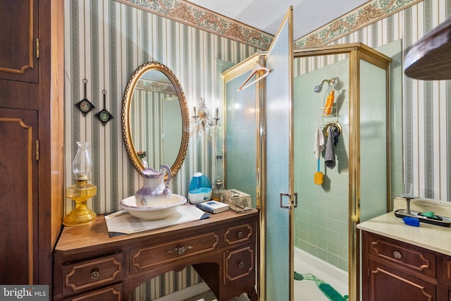 full bath with a shower stall, wallpapered walls, and vanity