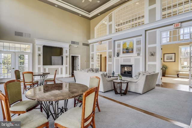 5856 Kittewan Ct, Manassas, VA 20112 - dining area featuring a towering ceiling, french doors, a fireplace, crown molding, and baseboards