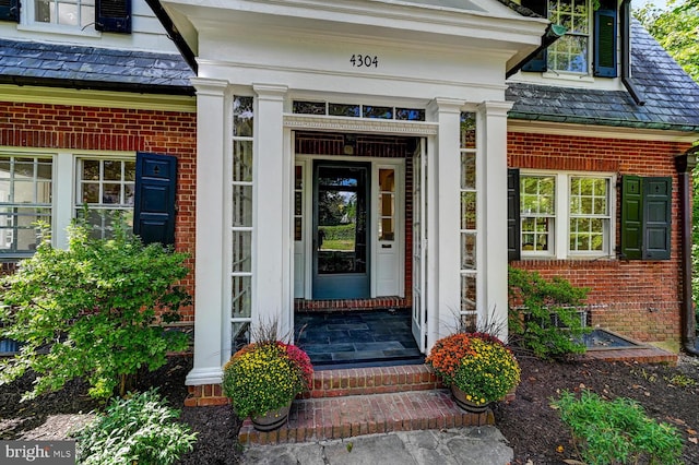 doorway to property featuring brick siding