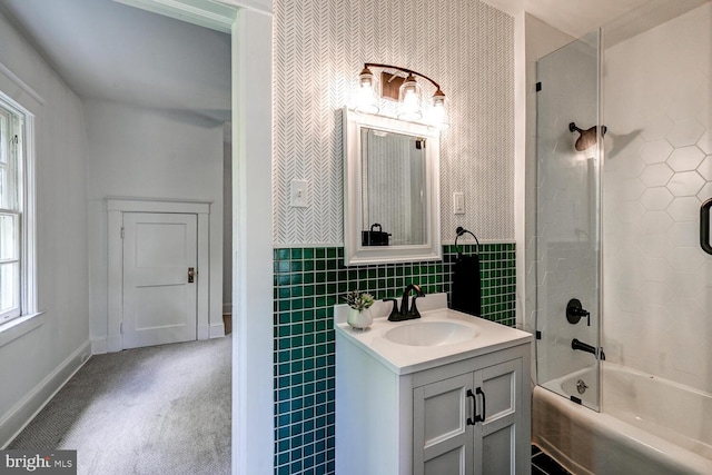 full bath with vanity,  shower combination, wainscoting, tile walls, and baseboards
