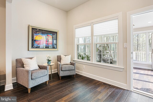 living area featuring baseboards, visible vents, and dark wood-style floors