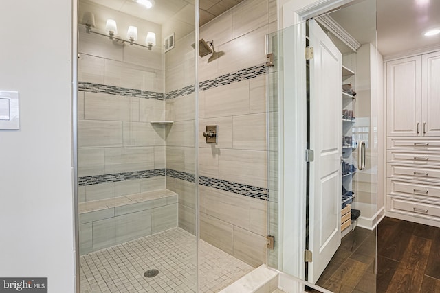 full bath featuring a shower stall, wood finished floors, and visible vents