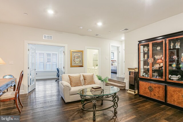 living room with baseboards, dark wood-type flooring, and visible vents