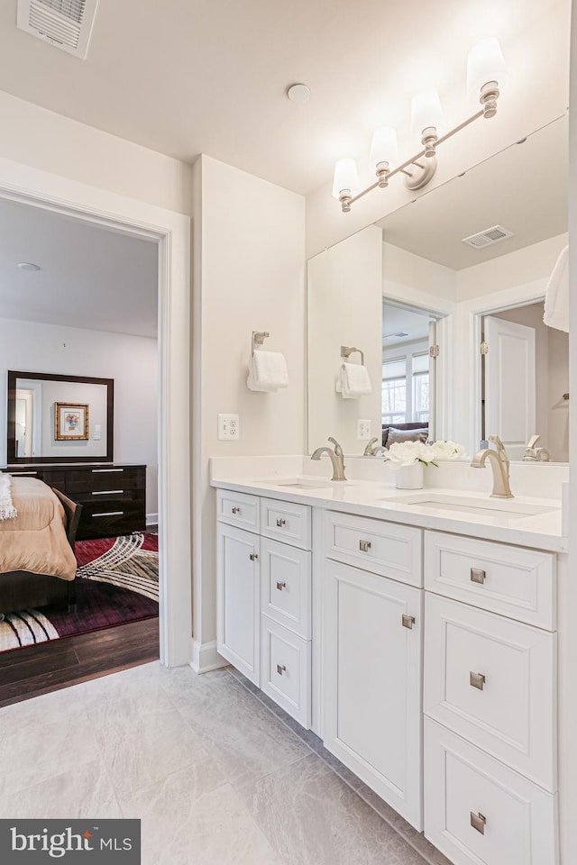 ensuite bathroom with visible vents, ensuite bathroom, and a sink