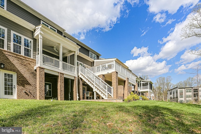 back of property with stairway, a yard, and a deck