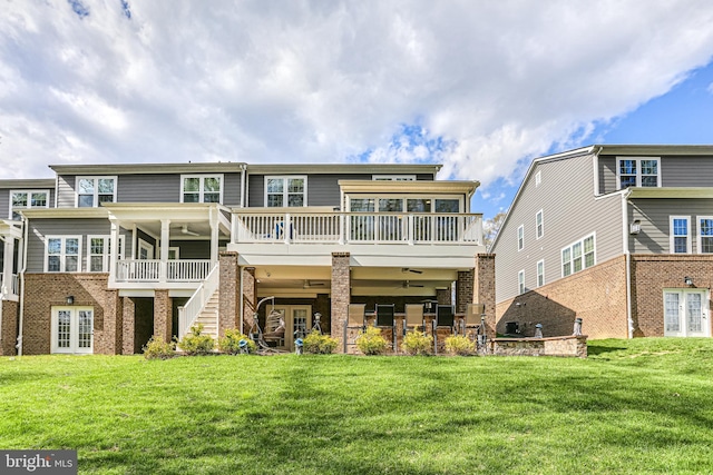 rear view of property with french doors, a lawn, stairway, and a deck