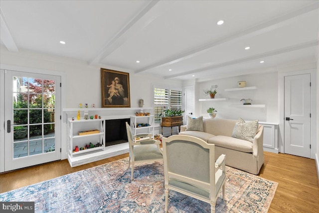 living area with light wood-type flooring, recessed lighting, and beam ceiling